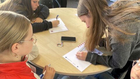 GirlsDay 2025 - AfB Büdingen Drei Personen beugen sich über einen runden Tisch