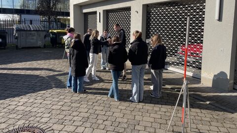 GirlsDay 2025 - AfB Fulda Mehrere Personen auf einem Hof vor vergitterten Toren