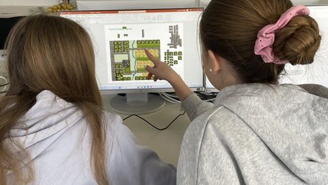 GirlsDay 2025 - AfB Fulda 2 Mädchen mit dem Rücken zur Kamera vor einem Monitor