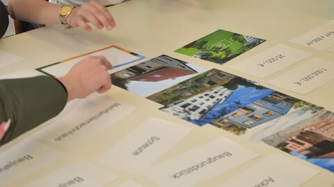 GirlsDay 2025 - AfB Korbach Zwei Hände an einem Tisch auf dem Bilder liegen