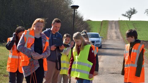 GirlsDay 2025 - AfB Korbach Mehrere Personen auf einem Feldweg mit Instrumenten zur Satellitenvermessung