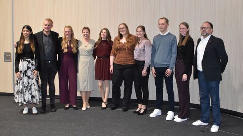 Akademische Abschlussfeier 2025 10 Personen nebenbeinander vor einer hellen Wand